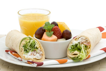 Healthy lunch - vegetarian wrap, fruit salad and orange juice