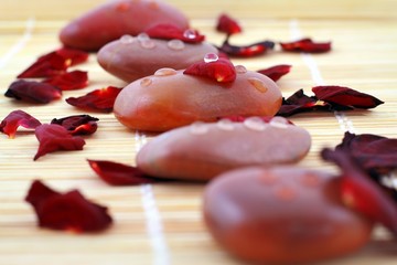 Spa composition of stones and red petals of rose