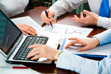 Image of three business people’s hands at working meeting