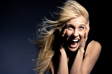 young blond woman screaming in fear, studio
