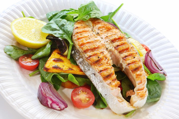 Salmon steak with roasted vegetables and spinach salad. 