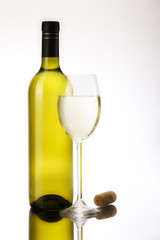 Glass of white wine and tall bottle