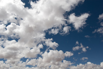 white clouds over deep blue sky background