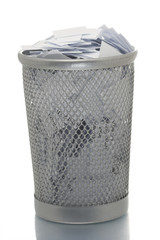 Mesh trash bin full of small paper pieces
