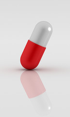 3d Rendered pill on reflective white plane.