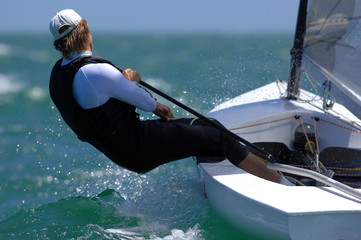 A lone sailor enjoys an outing in a small boat.