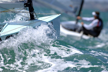 Sailors splash through the waves during a regatta.