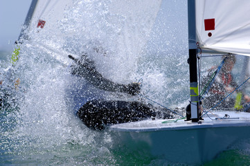 Sailors splash through the waves during a regatta.
