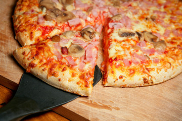 Pizza au fromage et champignons et morceau découpé