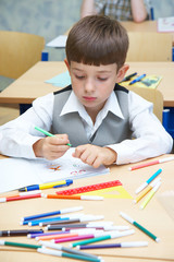 The boy draws felt-tip pens