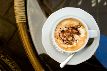 Cup of cappuccino on a table in Krakow outdoor cafe