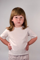 Pensive child wearing white t-shirt looking at you