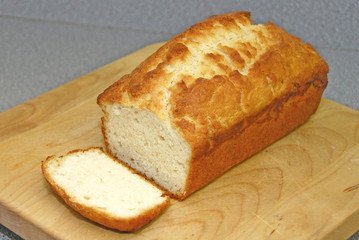 A slice of golden homemade bread on a wooden cutting board