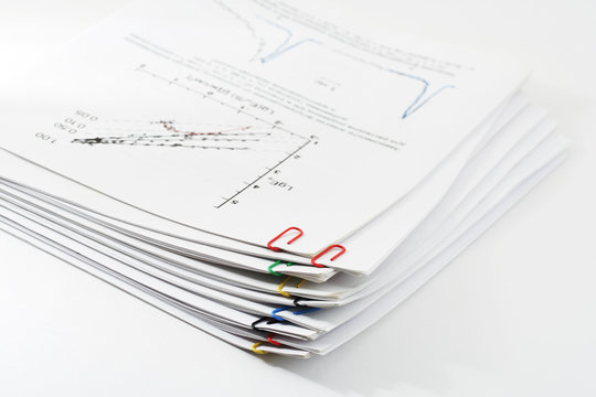 Pile of paper with graph clipping by paper clips