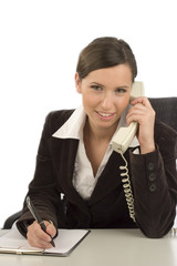 Young smiling businesswoman with telephone taking notes