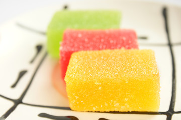 On a photo fruit candy of red, green yellow color.