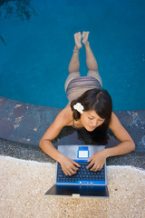 asian business woman working on laptop computer beside pool