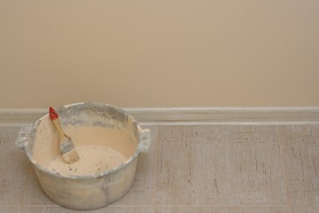 Busket with brush on the background of painted wall