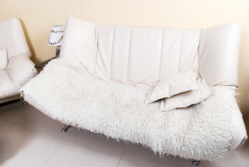 Fototapeta na wymiar Nowoczesna biała skórzana sofa z spadły.