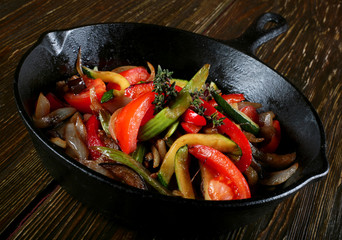 Fried vegetable with spice in black pan