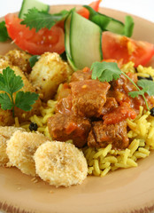 Beef vindaloo curry on tumeric rice with a side salad.
