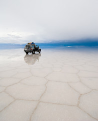 jeep in the salt lake salar de uyuni, bolivia