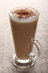 cafe - Coffee Latte with cocoa powder in a tall glass on burlap