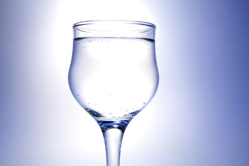 Nice goblet with drink and blebs on white-blue background