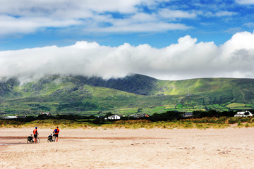 Randonneurs &agrave; v&eacute;lo sur plage au pied de montagnes