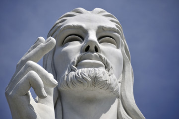 Jesus Christ statue against blue sky
