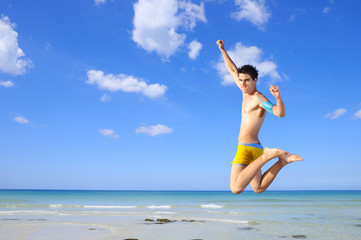 Obraz na płótnie Canvas Boy jumping on tropical beach