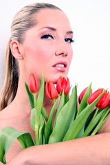 Schöne Blonde Frau mit langen Haaren Tulpen und Frühling grüße