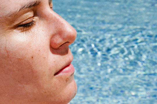 Femme bronzant près d'une piscine