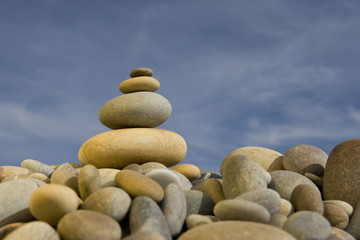 stack of round peebles with blue sky - zen and spa concept