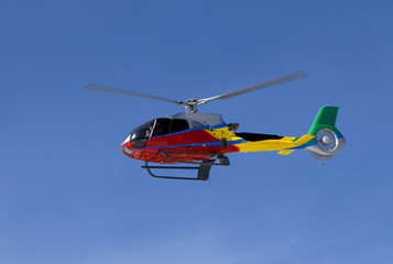 Obraz na płótnie Canvas Red Helicopter with team over blue sky