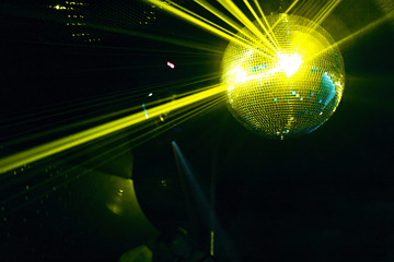 boule a facettes avec rayons laser jaune soirée en discothèque
