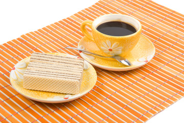 Waffle slice and cup with cofee on bamboo table-cloth