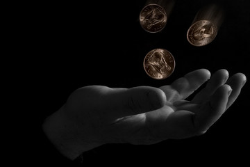 Fototapeta na wymiar Coins falling into a hand