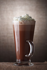 Hot Chocolate with cream in Tall Glass on brown rustic backgroun - 6613049