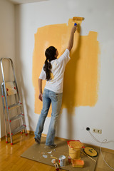 Junge Frau (Astrid, 23 Jahre) malt ihre erste Wohnung aus