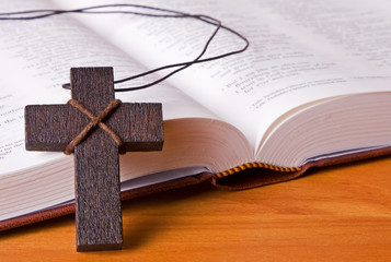 A wooden cross resting against a bible