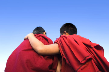 rear view of a monk holding another monk shoulder