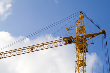 lifting crane under blue sky and white clouds