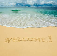 welcome written in a sandy tropical beach