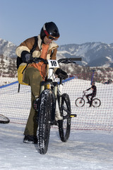 Biker in helmet in winter mountains Tien Shan at contest