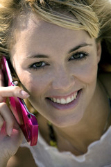  	Smiling confident woman holding a mobile phone