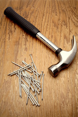 Hammer and nails on wooden panel