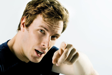 Young man with a serious look, pointing his finger outwards