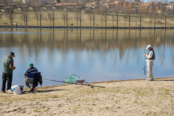 Trois hommes p&ecirc;chant en hiver au bord d'un lac ou d'un &eacute;tang