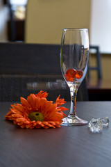 Wine-glass on a table near to a flower